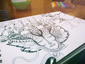 Detailed black and white doodle art on paper featuring whimsical figures and abstract designs.