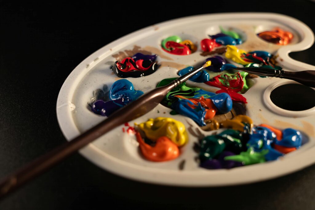 Close-up of a colorful paint palette with brushes, inspiring creativity.